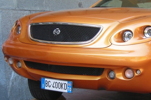 Narancssárga, gepárdszerű autó logója a torinói autómúzeum bejárata előtt 2003 májusában. Fotó: Kari