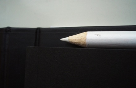 Fekete-fehér lanciás füzet, hozzávaló ceruzákkal